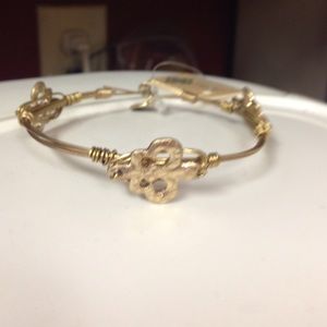 Worn gold wire bracelet w/flour De Lis casting.