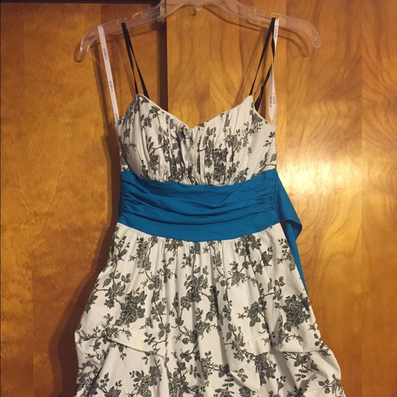 White dress with black design with blue tie.