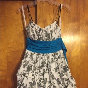 White dress with black design with blue tie.