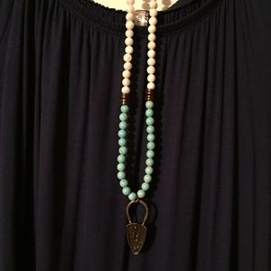 Long hand-beaded necklace with arrowhead pendant.