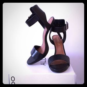 High-heeled black leather sandals