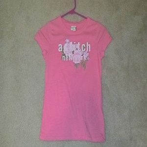 A pink shirt with sparkles across the too