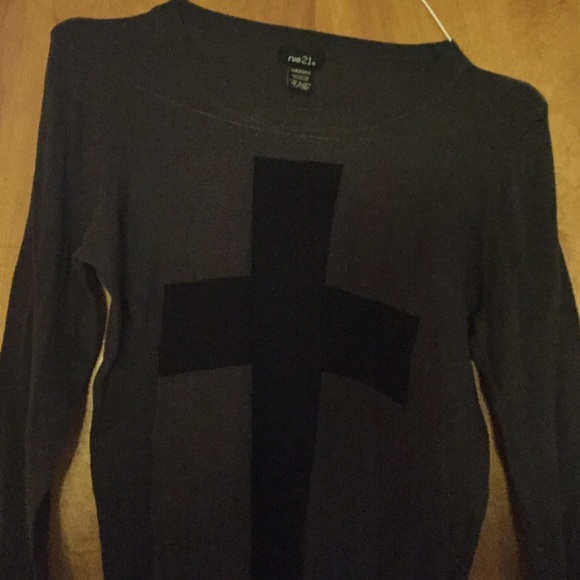 Grey sweater with black cross .