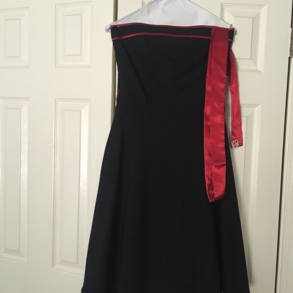 Strapless black dress with red sash and lace trim.