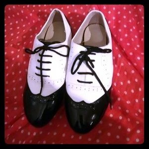Black and white wingtip flats.