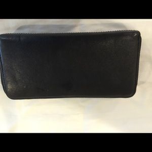 Black coach wallet with zipper closure.
