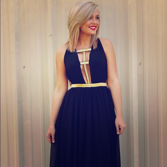 Floor length low-cut black dress with gold straps