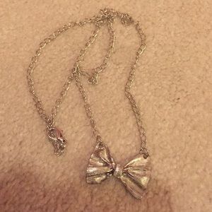 Silver bow necklace.