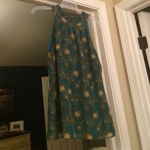 Sleeveless, high neck, peacock top.