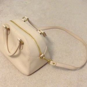 A cream colored shoulder bag