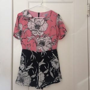 Romper in pink, black, and white floral print