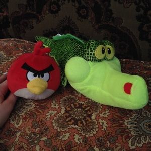 Red angry bird and green alligator stuffed animal.