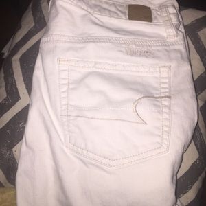 White ankle cut jeans with holes in the front.