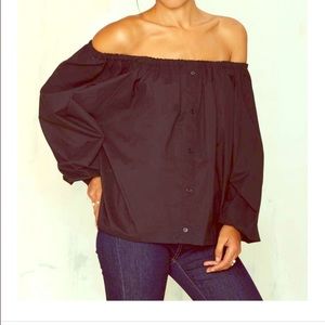 Black, off the shoulder long sleeved blouse.