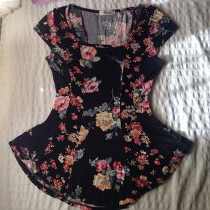 Black peplum shirt with flower patterns.