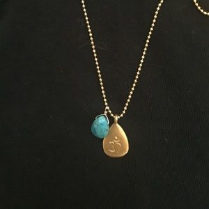 Satya gold necklace with OM charm and turquoise.
