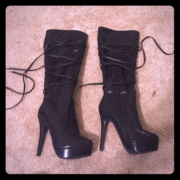 Black strappy high heeled boots.