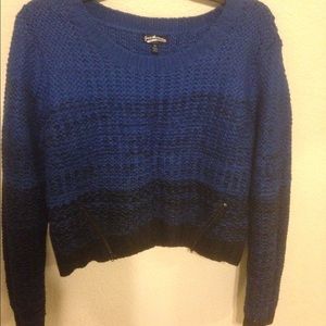 A mid drift blue and black sweater