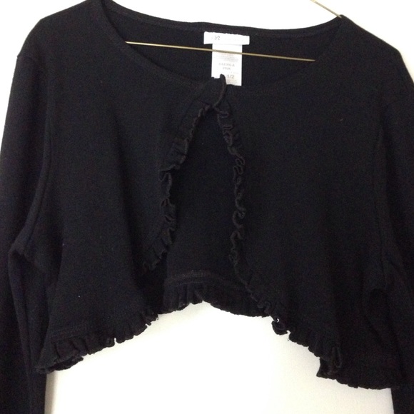 Long sleeve black shrug sweater with ruffles.