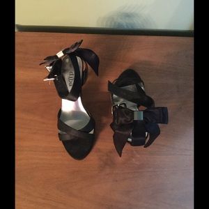 Black high heels. Bow on heel strap.