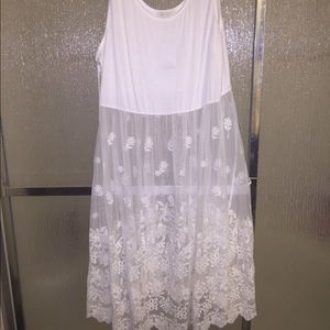 White dress with flower embroidered on the bottom.