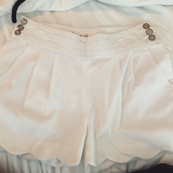 White shorts with scalloped hem and side buttons