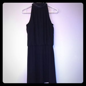 Sleek black dress with choker detail.