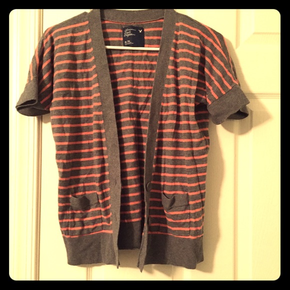 A gray and pink striped shirt sleeve cardigan.