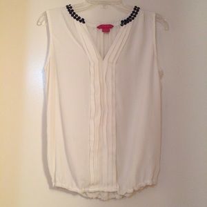 White sleeveless blouse with black studded collar