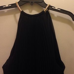 Pleated floor length gown. Gold necklace closure.