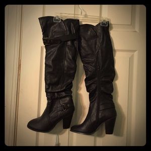 Knee length dark brown boots.