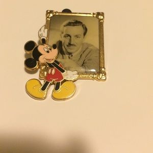 Mickey Mouse holding a picture of Walt Disney pin