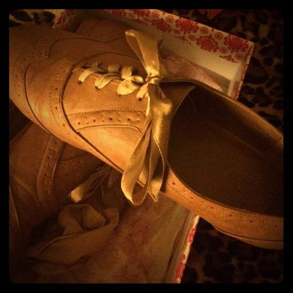 Tan, flat Oxford shoes.