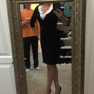 Black sweater dress with ruffled white collar.