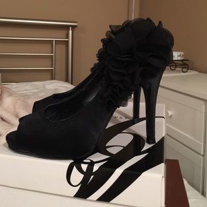 Peep toe high heels with flower decoration.