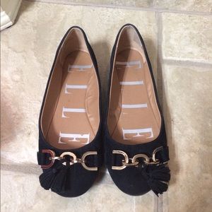 Black Elle flats with gold accents and tassels.