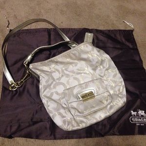 Champagne gold coach bag with two handles.