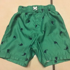 Green swim shorts with blue whales