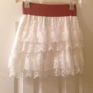 An adorable white mini skirt w/ brown strap