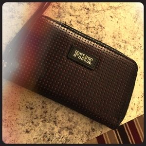 A Victoria secret pink wristlet .