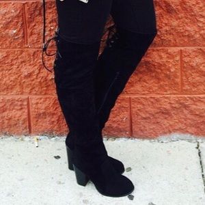 Thigh high black lace up boots.