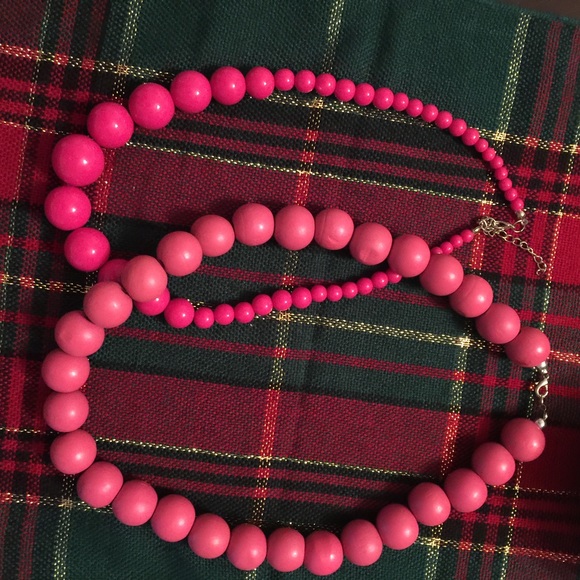 Two pink plastic and wood necklaces