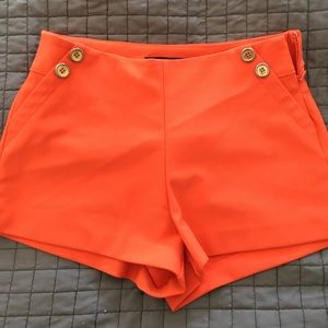 Orange shorts with gold button detail
