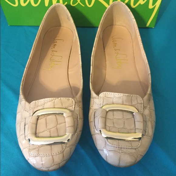 Beige ballet flats with gold accents.