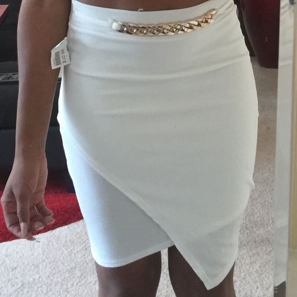 White asymmetrical skirt with gold link belt.