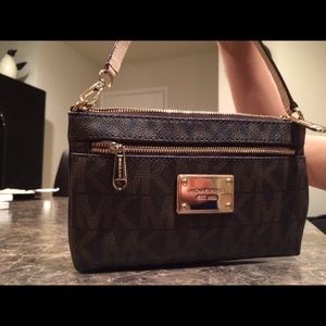 A small Michael Kors wristlet purse.