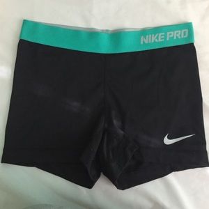 black and teal Nike pros