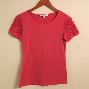 Salmon/pink colored top with textured sleeves