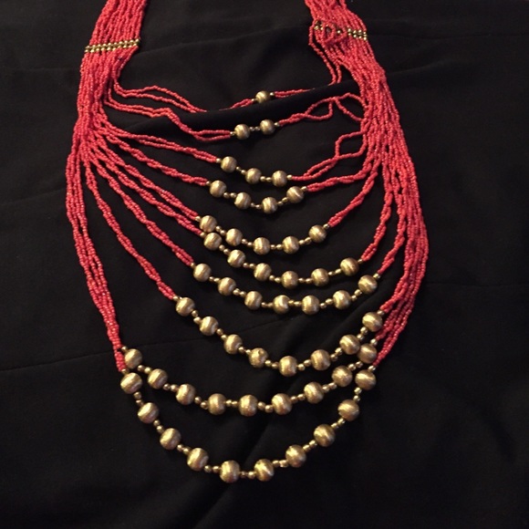 Long multi stranded red and gold accent necklace.