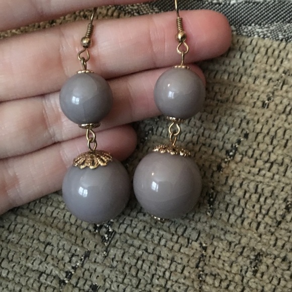 Grey and gold colored hanging ball earrings.